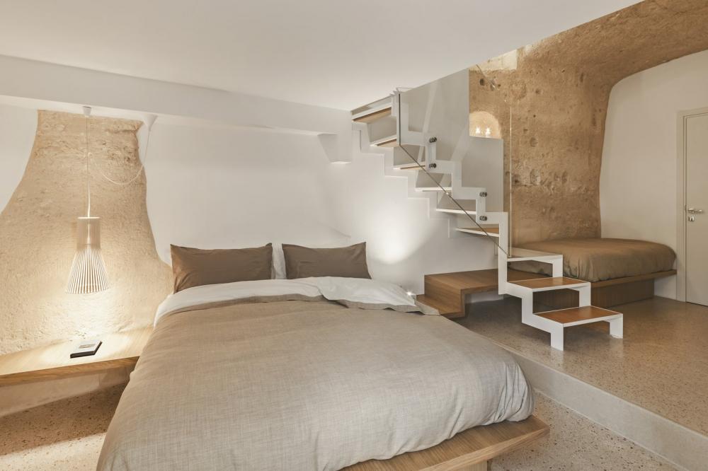 Phòng ngủ thiết kế với gam màu trung tính, tương đồng với màu của vách hang động
