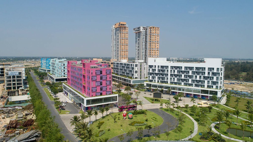 Dự án condotel Cocobay Đà Nẵng gồm nhiều tòa nhà cao tầng đã xây dựng, bên cạnh có công viên cây xanh và đường đi
