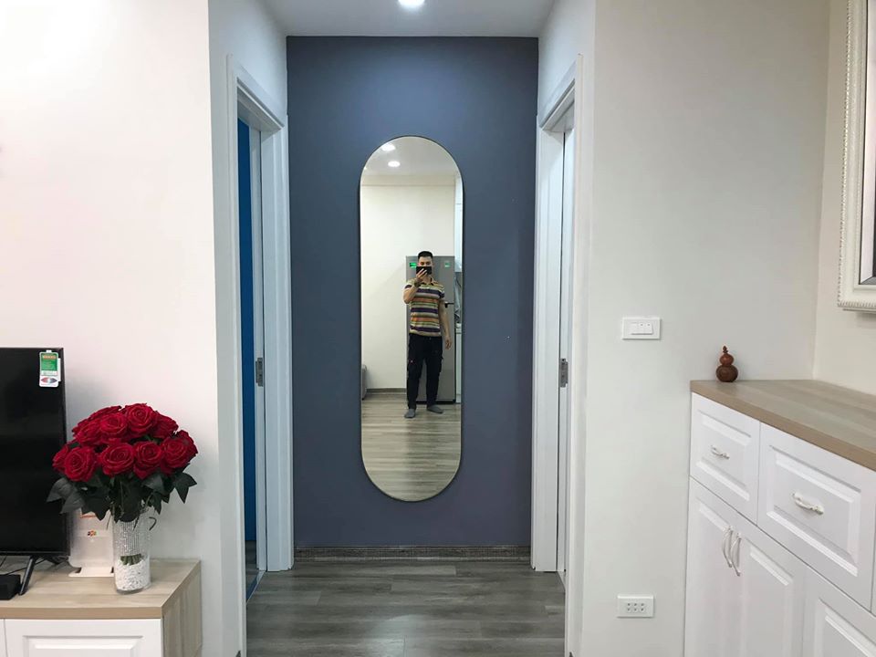 người đàn ông đứng chụp ảnh trước gương