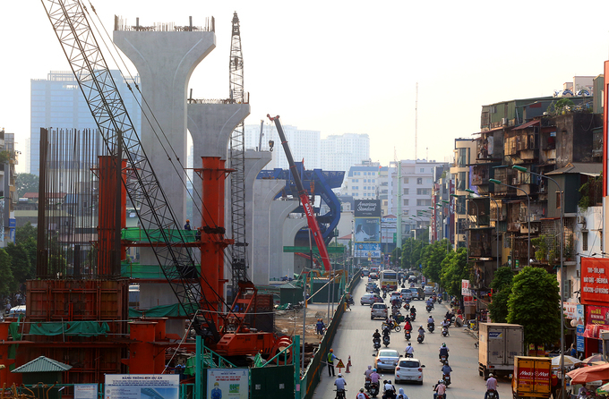 Đường trên cao đang xây dựng ngổn ngang, dưới là đường đi lại, xung quanh có những dãy chung cư cũ xuống thấp, những ngôi nhà gần công trường sẽ bị phạm thiện xạ sát.