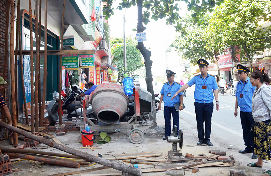 3 người đàn ông và một phụ nữ đang đứng trước một ngôi nhà đang thi công xây dựng