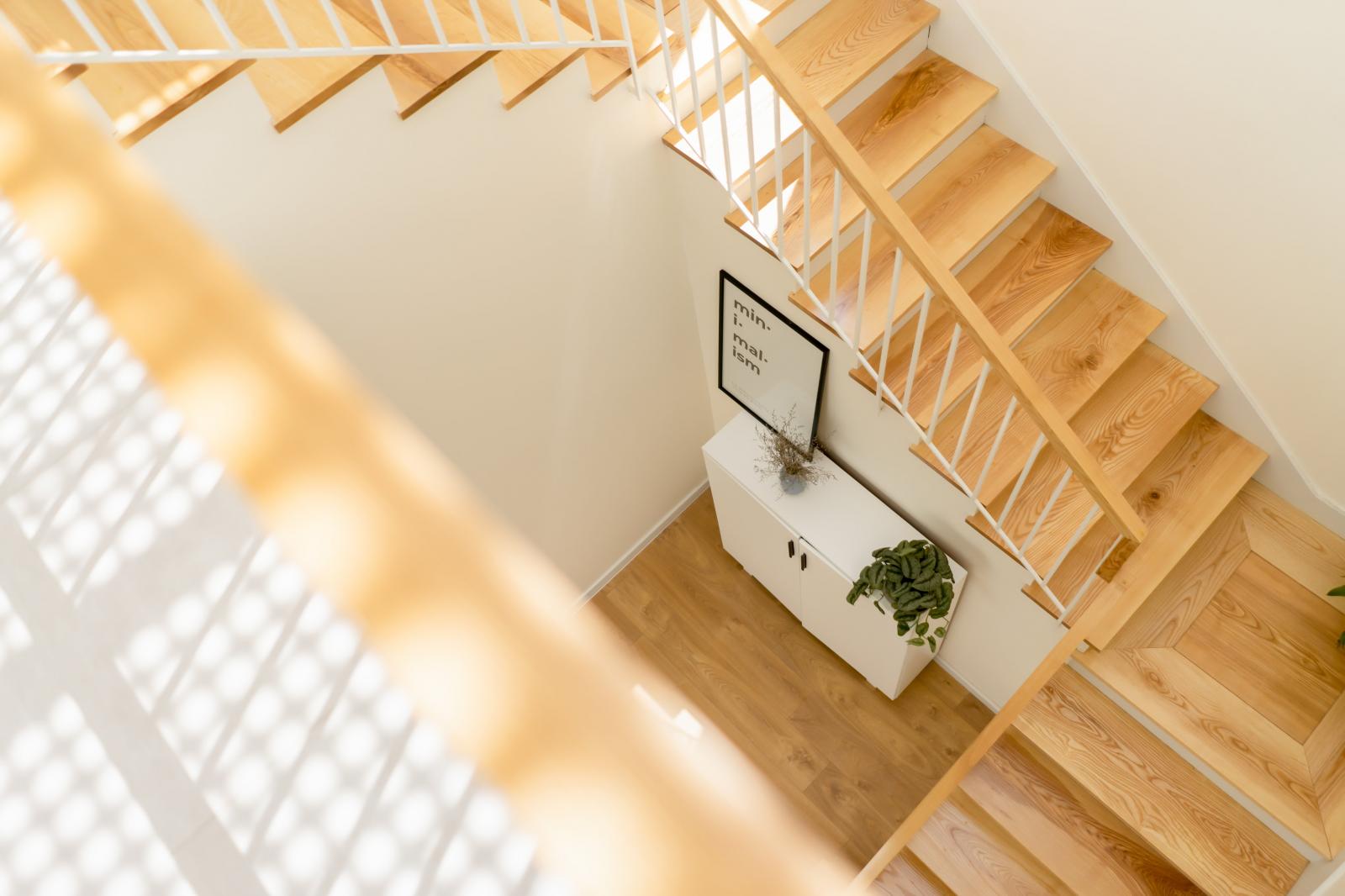 Cầu thang bằng gỗ sáng màu kết nối 2 tầng nhà.
